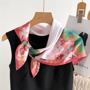 Satin silk scarf with pink lotus floral print styled on a black dress and wooden hanger