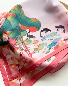 Detailed shot of lotus and koi carp print on a silky pink square scarf with rolled hem