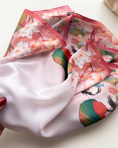 Detail of silk-like scarf featuring elegant lotus print and smooth satin texture