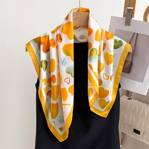 Foulard quadrato in seta con cuori gialli drappeggiato su abiti eleganti