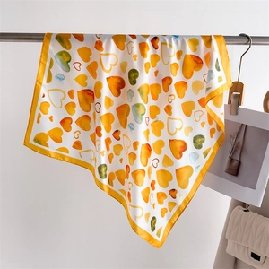 Dettaglio di un foulard in seta con stampa a cuori, drappeggiato con colori vivaci e stile
