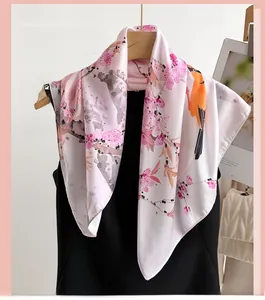 Macro detail of silk scarf featuring cherry blossoms and an orange bird print