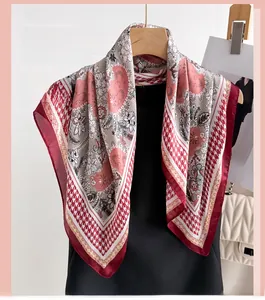 Detail of elegant floral print silk-like scarf with classic red houndstooth border