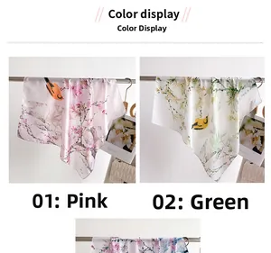 Detail of pink and green floral bird print silk scarves hanging on metal rods