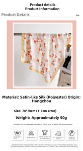 Close-up of 70cm satin silk scarf with orange and blue floral patterns and gold hem