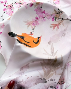 Close-up of faux silk scarf showing delicate floral and bird print with smooth texture