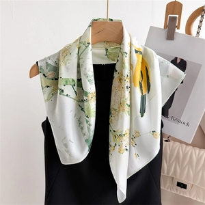 70cm silk scarf with floral and bird prints over cream base on a wooden hanger