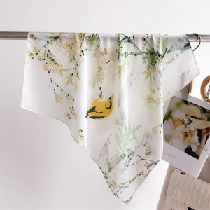 Detail of floral and bird print silk scarf hanging gracefully with elegant drapes