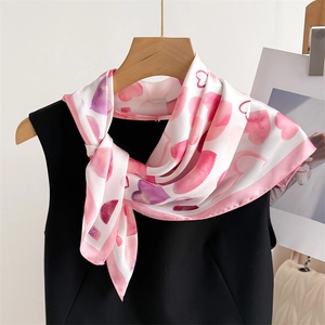 Dettaglio della stampa a cuore acquerello sul foulard di seta annodato su un abito