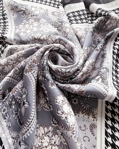 Macro shot of silk-like scarf texture featuring houndstooth and paisley print patterns