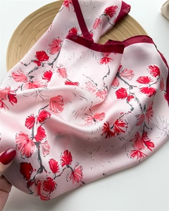 Detailed texture of 70cm silk-like scarf with vibrant floral print on light pink base