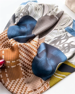 Detail of silk-like scarf with blue and brown geometric plaid patterns and soft texture