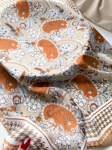 Detailed view of paisley silk-feel scarf showing soft draping and houndstooth edge pattern