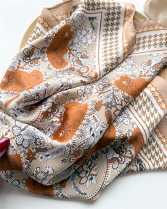 Detail of silk-like square scarf featuring houndstooth and floral patterns in khaki orange