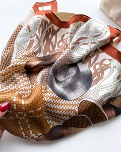 Close-up of vibrant orange and mocha checkered silk scarf with satin texture and print