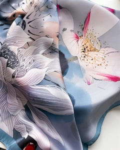 Vue détaillée du motif de lotus sur le foulard en soie synthétique bleu-gris