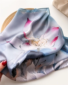 Détail de foulard en soie avec imprimés de lotus élégants et bordures bleues roulées