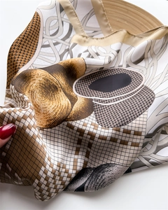 Detail of silk-like square scarf featuring abstract geometric print and smooth texture
