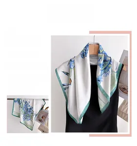 Detail of silk scarf with blue iris floral print and elegant green border finish