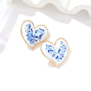 Detail of blue and white marble enamel heart earrings with gold-plated metal edges
