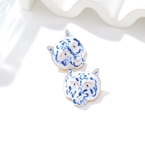 Chic enamel tiger stud earrings with blue floral patterns and gold metal edges