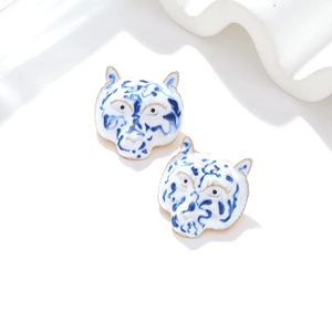 Enamel tiger head stud earrings with blue and white floral porcelain style design