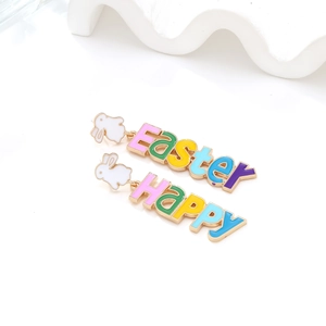 Detail of Easter bunny drop earrings with colorful enamel letters and gold finish