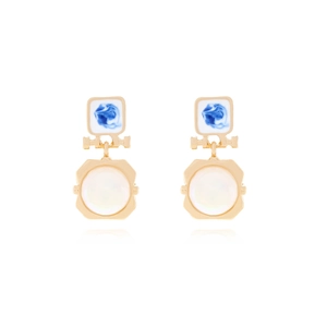 Detailed view of golden earrings with blue enamel accents and white pearl drop pendants