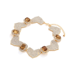 Collier ras du cou doré à cœurs pavés de cristaux et pierres ambrées sur fond blanc