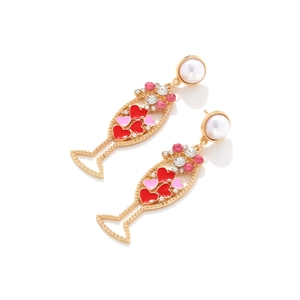 Detail of gold champagne glass earrings with enamel hearts and small crystals
