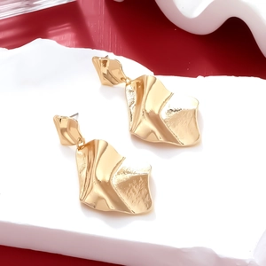 Detail showing wavy textured golden alloy geometric drop earrings with mirror finish