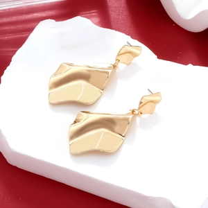 Exaggerated golden alloy wave drop earrings with irregular textured surface design