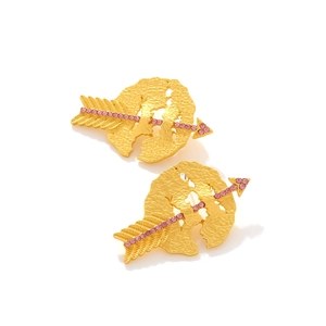 Detail of gold cupid arrow earrings with pink crystals and hammered metal texture