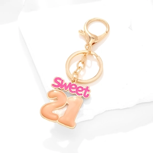 Pink gradient Sweet 21 keychain with lobster clasp on white stone display