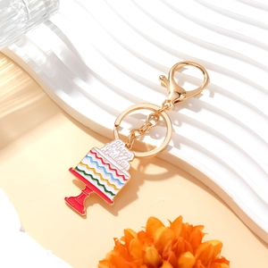 Colorful rainbow birthday cake keychain with Happy Birthday charm on white ripple base