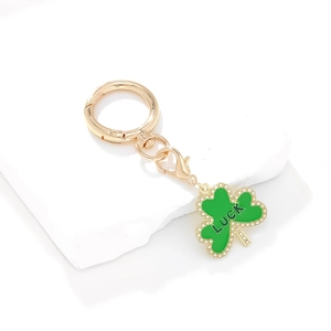 Détail du porte-clés trèfle vert avec lettrage Luck doré et bordure en perles
