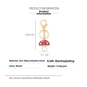 Detailed view of 10.8cm red enamel mushroom keychain with faux pearls and rhinestones