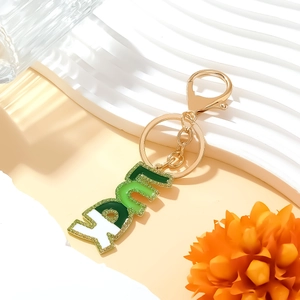Porte-clés lettre Lucky en émail dégradé vert avec strass brillants et finition dorée