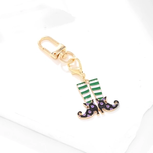 Colorful enamel witch boot keychain with green stripes and purple polka dots in gold metal