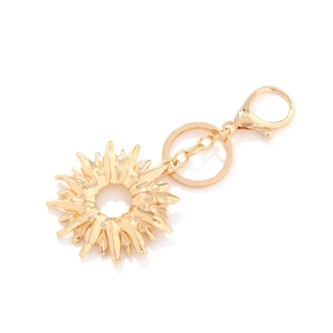 Golden sun pendant keychain with radiating spike design and polished metallic finish