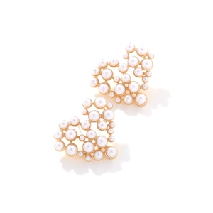Detailed view of heart-shaped hollow earrings with gold metal and white pearls