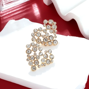 Detailed view of gold alloy heart earrings with sparkling pavé zircons on stone display