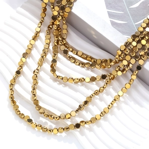 Vintage multilayered gold faceted bead necklace displayed on a white wave tray