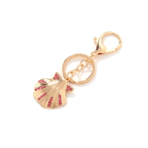 Golden shell keychain with pink rhinestones and lobster clasp on white background
