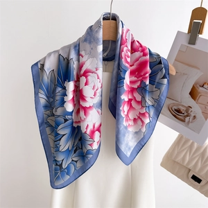 Elegant silk scarf with blue and pink peony floral patterns on a white background