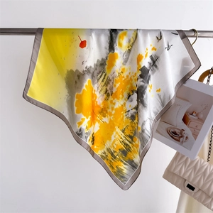 Detail of yellow and grey artistic silk scarf with ink wash bird and leaf pattern
