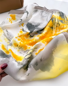 Detailed macro view of the abstract ink print silk scarf with yellow and grey patterns