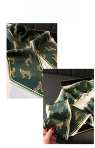 Detail of elegant dark green leopard print silk scarf with striped border and satin sheen