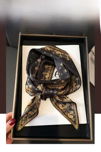 Gros plan détaillé d'un foulard en satin noir avec un imprimé à motifs paisley dorés
