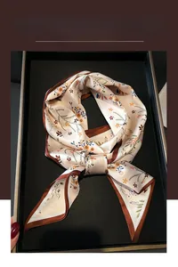 Détail d'un foulard en soie à fleurs avec reflet perlé et bordures marron élégantes